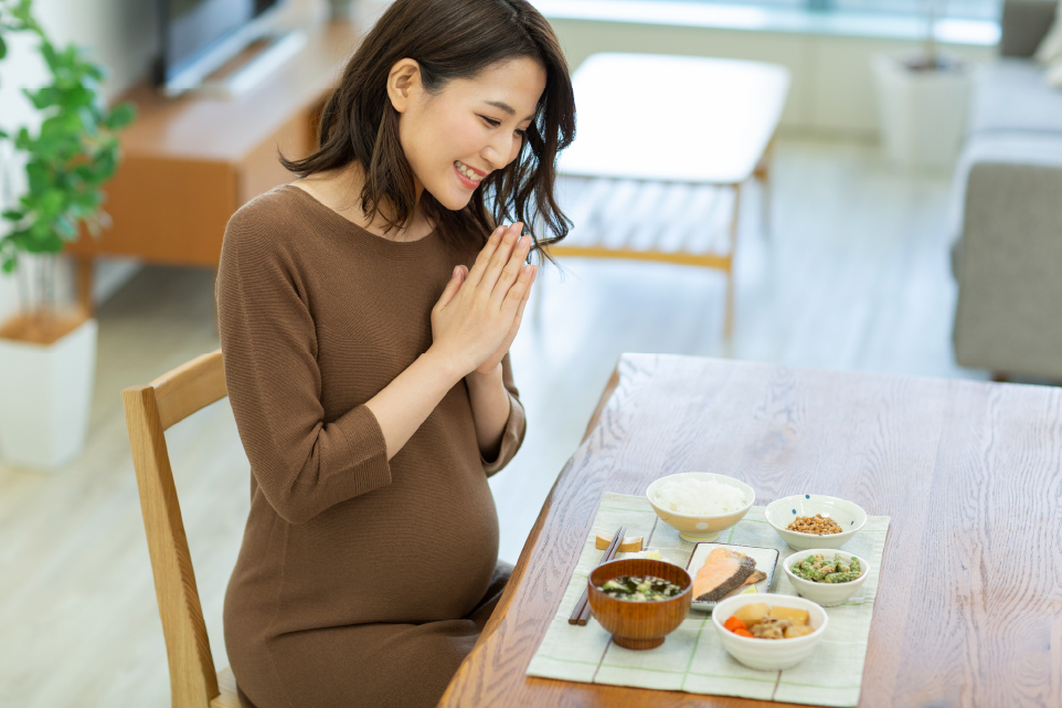 食事を前に手を合わせている妊婦さん